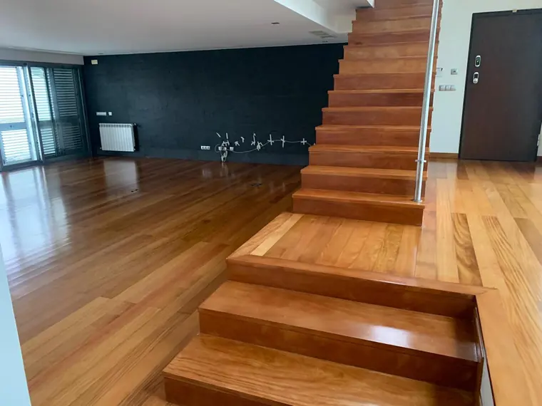 Sala e escadas com pavimento de madeira aplicado pela BrilhoTec