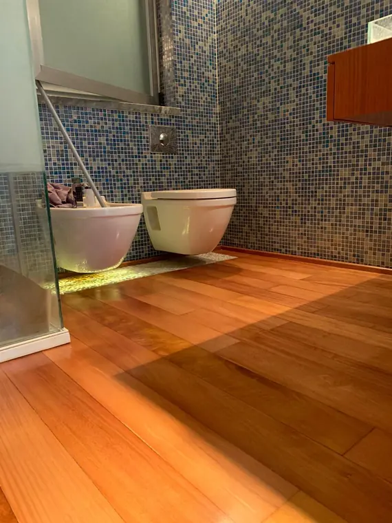 Soalho corrido em madeira envernizado numa casa de banho