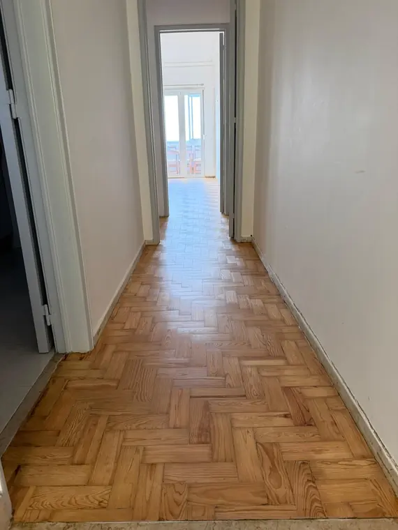 Corredor com pavimento de madeira reparado e uniforme